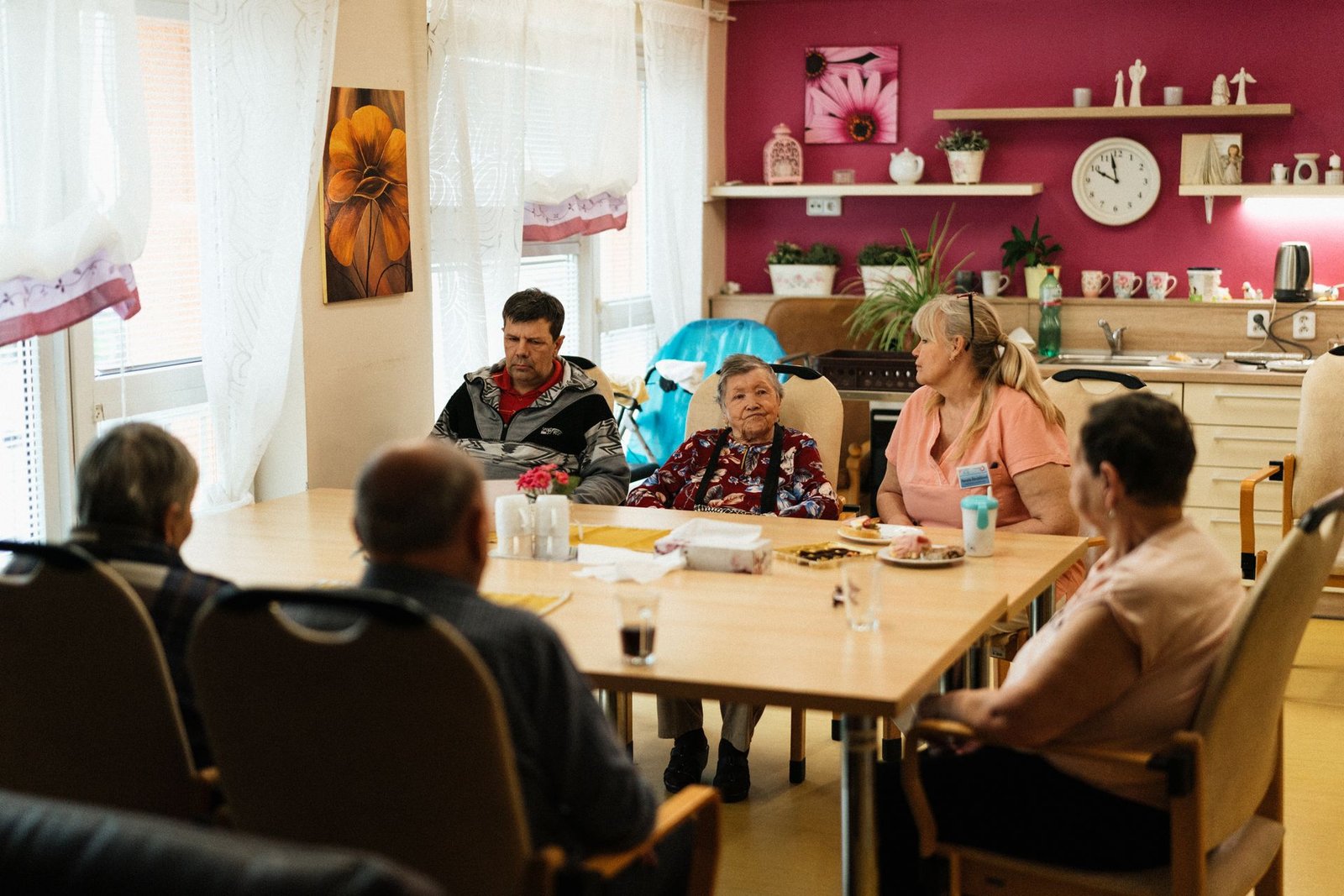 Caregivers and seniors enjoying a meal together in a dining setting