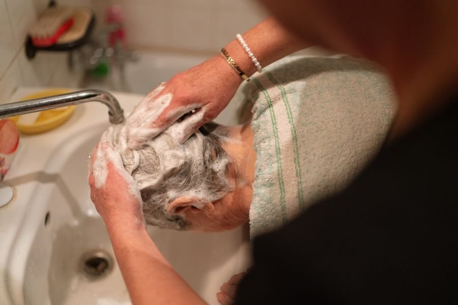 Caregiver gently supporting personal care at home